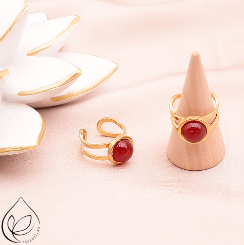 Deux bagues en cornaline style Azélis doré sur un fond clair et lumineux : une bague posée à plat et l’autre sur un petit présentoir en forme de cône, pierre centrale de 10 mm, monture en acier inoxydable 304 professionnel, bagues artisanales, couleurs orange et doré, bijou élégant et durable, idéal pour style et bien-être.