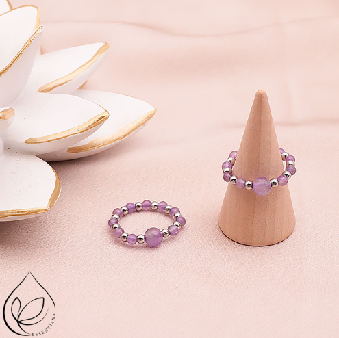 Deux bagues argentées en hématite et améthyste sur un fond clair et lumineux : une bague posée à plat et l’autre sur un petit présentoir en forme de cône, perles de 3 à 6 mm, bagues artisanales, pierres naturelles qualité A, couleurs argenté et violet, bijou élégant et harmonieux.